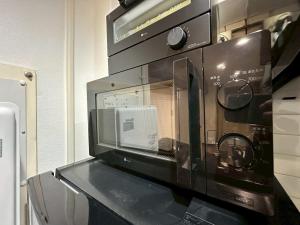 eine Mikrowelle auf einer Theke in der Unterkunft NEW PS508 Susukino Family Room in Wada + 27 Fotos