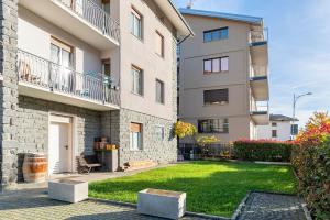Un edificio de apartamentos con césped delante. en Casa Vacanze Dal Castelin, en Valtellina
