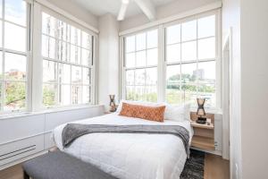 a bedroom with white walls and windows and a bed at The 333 Suites 303 - Suite for 6 in Cincinnati