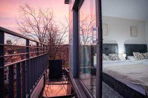 einen Balkon mit einem Bett und einem Fenster mit Aussicht in der Unterkunft Penthouse in Central Nottingham with Hot tub and Games in Nottingham
