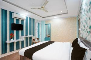 Un televizor și/sau centru de divertisment la Townhouse Shri Mahakaleshwar Jyotirlinga Ujjain Formerly Hotel Shikhar Darshan +24 fotografii