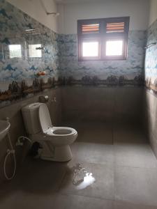 een badkamer met een toilet en een raam bij Circle Edge Cabana in Kandy