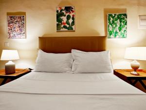 Un dormitorio con una cama blanca con dos lámparas. en Birgu 3, en Cospicua