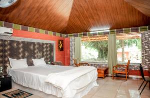 a bedroom with a large bed with a wooden ceiling at Misty Night Wayanad Pool Resort in Wayanad