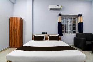 a bedroom with a large white bed and a chair at Hotel O Samrat Palace in Bārang