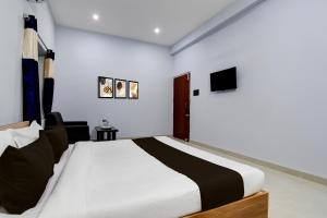 a bedroom with a large bed and a tv at Hotel O Samrat Palace in Bārang