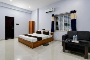 a bedroom with a bed and a couch and a chair at Hotel O Samrat Palace in Bārang +13 photos