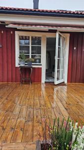 a porch of a red house with two potted plants at Studio Borgen in Sigtuna