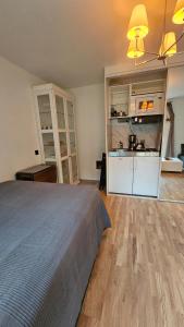 a bedroom with a large bed and a kitchen at Studio Borgen in Sigtuna