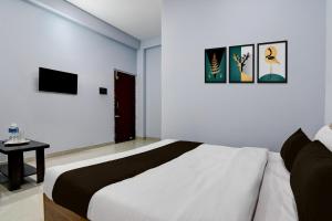 a white bedroom with a bed and a table at Hotel O Samrat Palace in Bārang