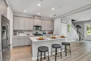 a kitchen with white cabinets and a island with bar stools at Sunny Amp Bright Modern Retreat in Davenport
