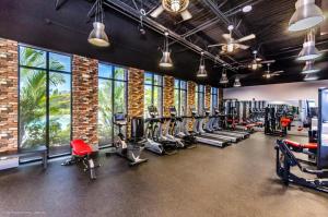 a gym with rows of treadmills and machines at Sunny Amp Bright Modern Retreat in Davenport