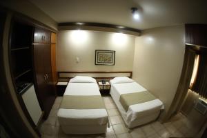 帕拉卡图Hotel Veredas的一间医院间,配有两张床和一张桌子