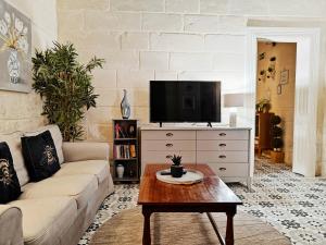a living room with a couch and a tv at Birgu 3 in Cospicua