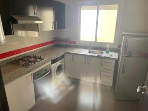 a kitchen with a sink and a washing machine at Magnifique Appartement à Louer C14 Jnane Dalya in Bouznika