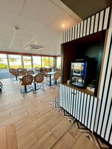 een eetkamer met tafels en stoelen en een flatscreen-tv bij B&B HOTEL PERPIGNAN Nord Aéroport in Perpignan