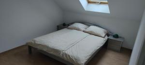 a small bed with white sheets and pillows on it at Grüne Auszeit Dresden in Dresden