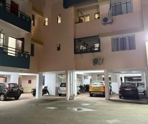 een parkeerplaats met auto's geparkeerd voor een gebouw bij 3BHK Flat Rudrashakti Enclave Nagpur in Nagpur