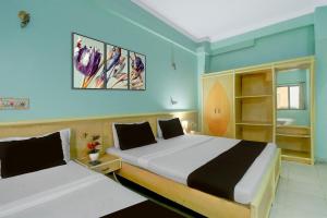 a bedroom with two beds and blue walls at Collection O Albert Hall Museum Jaipur Formerly Roop Palace in Jaipur