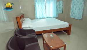 a small bedroom with a bed and a chair at vks holiday homes in Malpe
