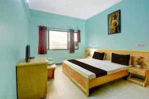 a bedroom with a bed and a television in it at Collection O Albert Hall Museum Jaipur Formerly Roop Palace in Jaipur