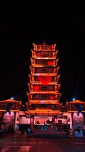 uma grande torre com um coração no topo à noite em GUI YUAN ZHEN PIN HOTEL,Approximately 3km away from the east gate of Zhangjiajie National Forest Park,Free Chinese western Breakfast,Free Self-Service Laundry , Attraction Tickets Serivce in advance,Free one-way shuttle service for 4 nights or more em Zhangjiajie