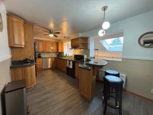 uma cozinha com armários de madeira e uma bancada em Entire floor in a Spacious bungalow ensuite close to beach and train em Pincourt