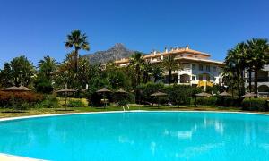 a large blue swimming pool in front of a building at Marbella - Puerto Banus in Marbella