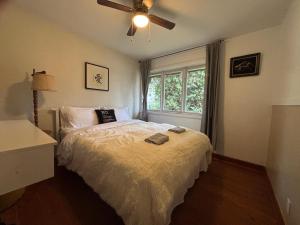 um quarto com uma cama e um ventilador de teto em Entire floor in a Spacious bungalow ensuite close to beach and train em Pincourt