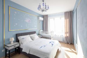 a bedroom with a bed and a chandelier at New апартаменты возле Материнства и Детства in Taldykolʼ