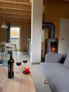 a living room with a bottle of wine and a candle on a table at Haus Meerschilf in Klausdorf Mecklenburg Vorpommern