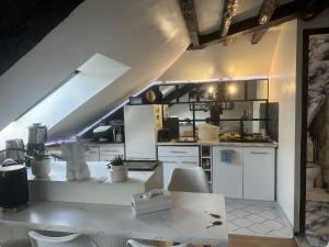 a kitchen with white cabinets and a table and chairs at Appartement dans la Résidence le Chateaux in Fitz-James