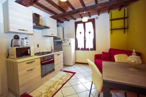 a kitchen with a table and a red couch in a room at Guest House Formigine in Formigine