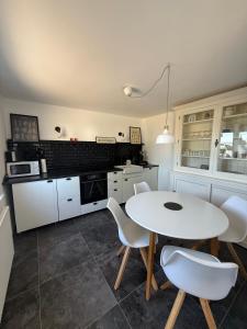 a kitchen with a white table and white chairs at BAN 01A in Gremersdorf
