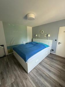 a bedroom with a large bed with a blue blanket at BAN 01A in Gremersdorf