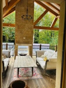 a living room with two couches and a table at Villa Nature & Douets - aux portes du Mans - 5 chambres climatisées - piscine à débordement et terrain arboré d'1 hectare in La Chapelle-Saint-Aubin