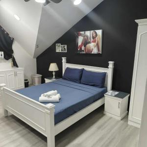 安吉利斯Kandi Suites 2BR with private Jacuzzi 500 Mbps internet的卧室里有一张床，床单是蓝色的，墙壁是黑色的 更多134张照片