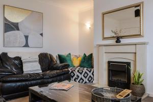 a living room with a leather couch and a fireplace at Danby House Messingham nr M181 Motorway - Humberside Airport, Elsham, Lincoln - We welcome Family & Contractor Stays in Messingham
