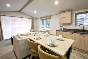 ヨークにあるFir Tree Lodge with Hot Tubのテーブルと椅子のあるキッチンとリビングルーム
