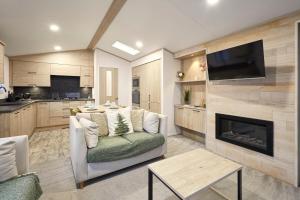 ヨークにあるFir Tree Lodge with Hot Tubのソファと暖炉のあるリビングルーム +29枚の写真