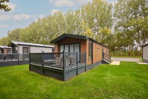 ヨークにあるFir Tree Lodge with Hot Tubの庭にデッキがある小さな家