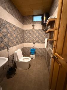 ein kleines Badezimmer mit Toilette und Waschbecken in der Unterkunft Khili's Abode in Harsil