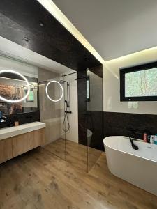 a bathroom with a white tub and a sink at Chata w Puszczy Nowa Łuka in Łuka +20 photos