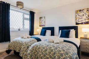 two beds in a bedroom with blue and white at 3-Bed Retreat Perfect Contractors & Leisure Stays Onsite Parking in Messingham