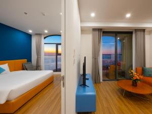 a bedroom with a bed and a room with a tv at Atermis Regency Hillside Phu Quoc - Sea & Fireworks view- Gym & Pool Access in Phu Quoc +126 photos