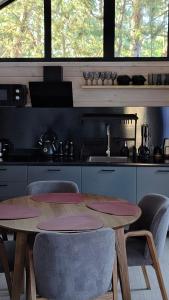 y cocina con mesa de madera, sillas y fogones. en Лісове SPA, en Vishenki 10 fotos más