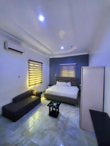 ポートハーコートにあるQuintessential Hotelのキングサイズのベッドとソファのある寝室