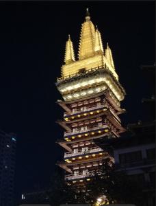 a tall building with a golden roof at night at Tech-X Jing'an Hotel in Shanghai
