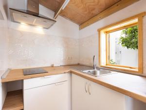 a kitchen with white cabinets and a sink and a window at Live Villa Adrian in Caleta de Interián