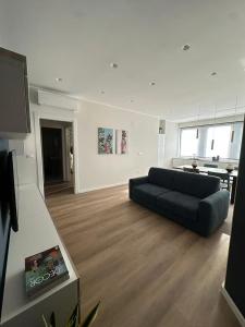 ein Wohnzimmer mit einer schwarzen Couch und einer Küche in der Unterkunft Suite Design in Pescara